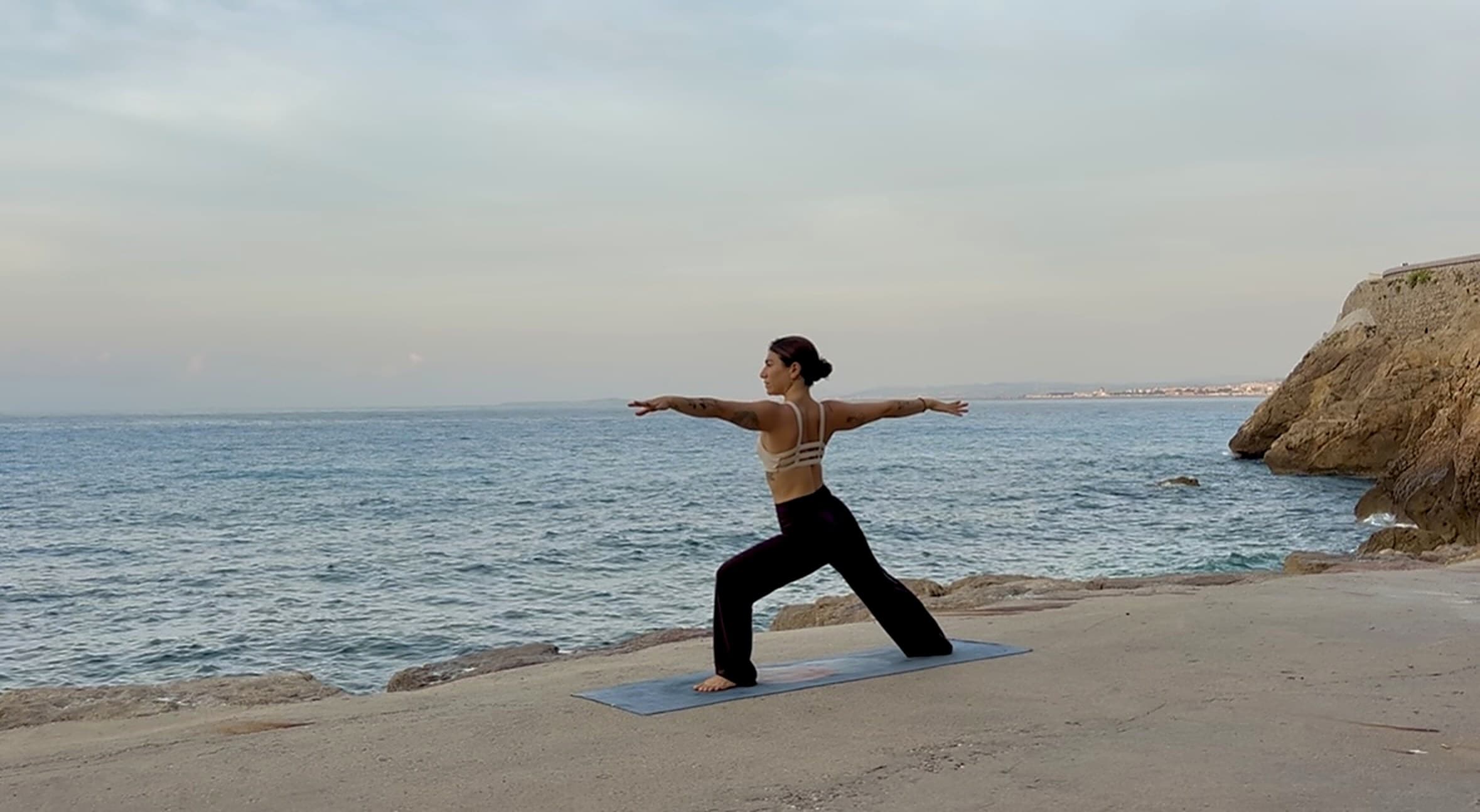 warrior pose by the sea at dusk in Nice