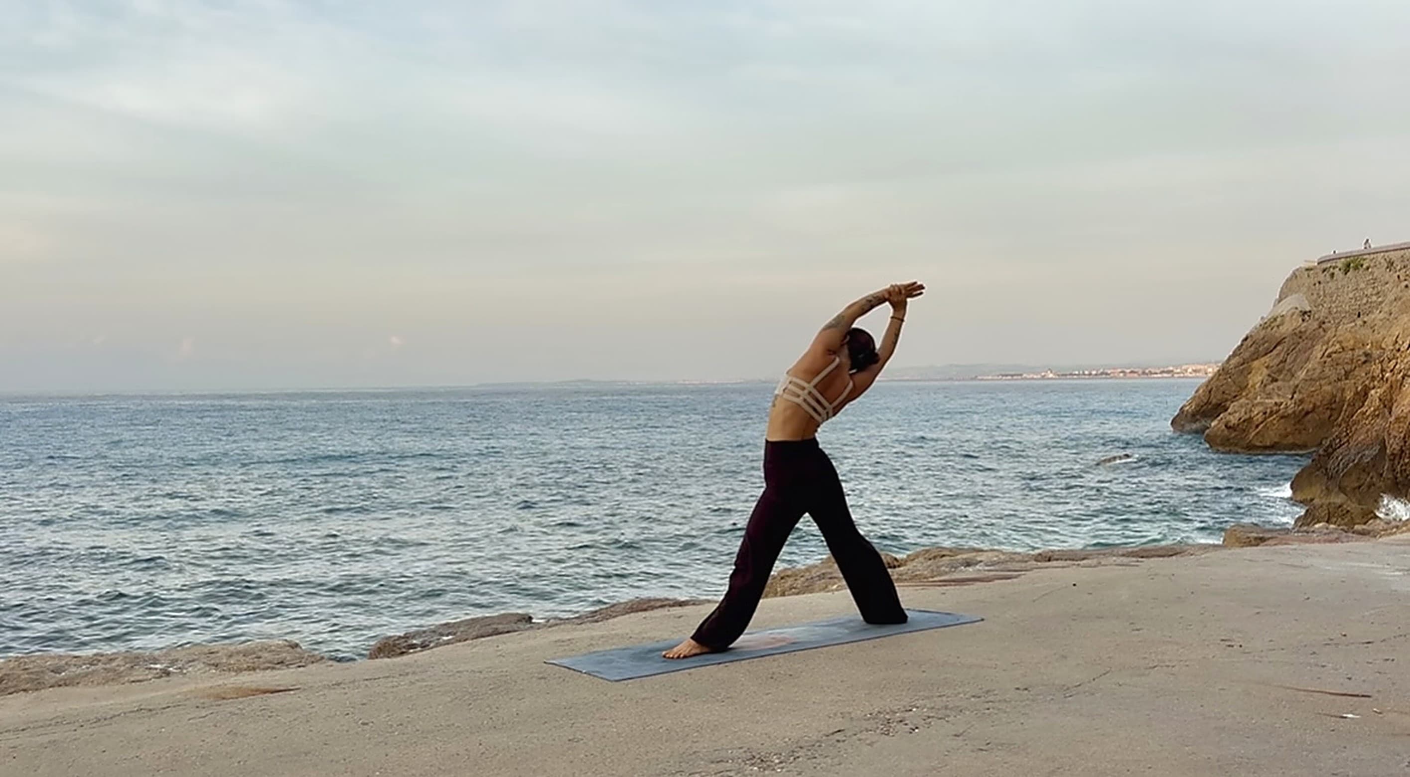standing side stretch by the sea at dusk in Nice